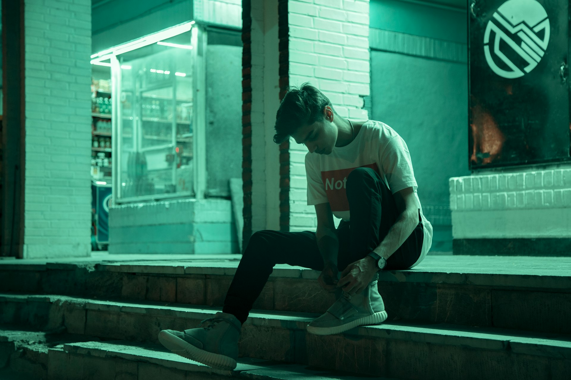 man sitting on stairway during nighttime